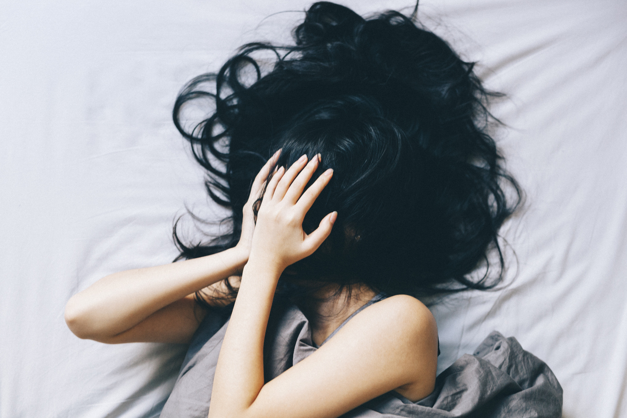nerwica lękowa powoduje, że kobieta leży smutna w łóżku 