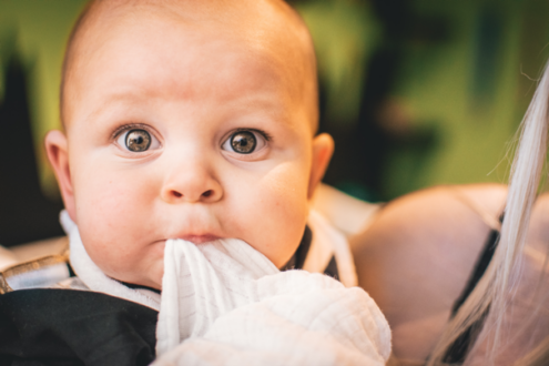 niemowlak trzyma w ustach kawałek pieluszki
