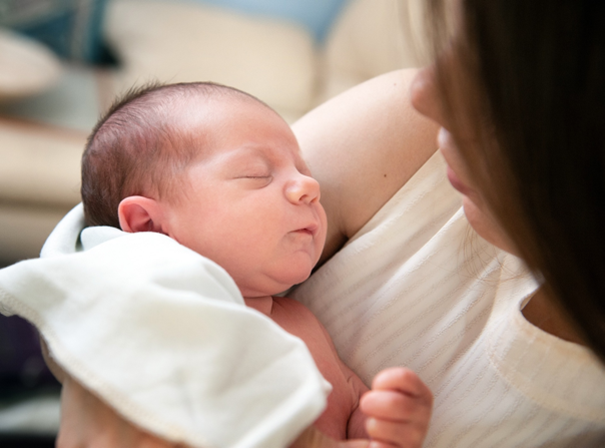 noworodek po karmieniu piersią śpi w objęciach mamy